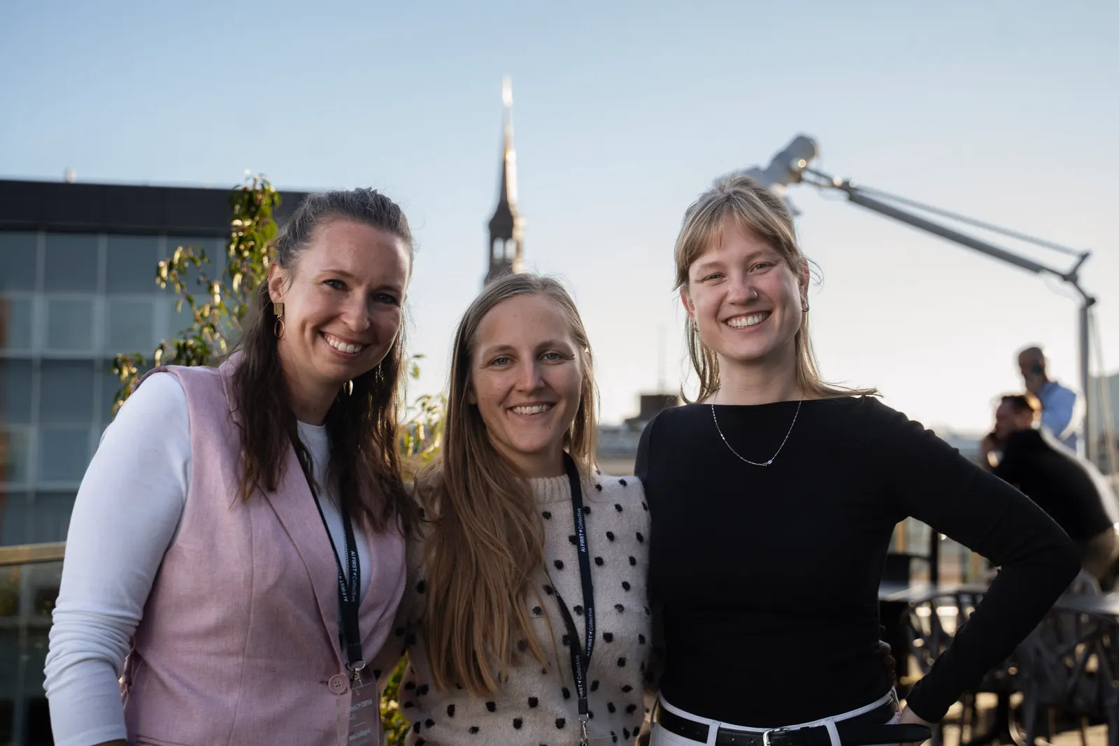 Drei Mitglieder lachen gemeinsam auf der Dachterrasse.