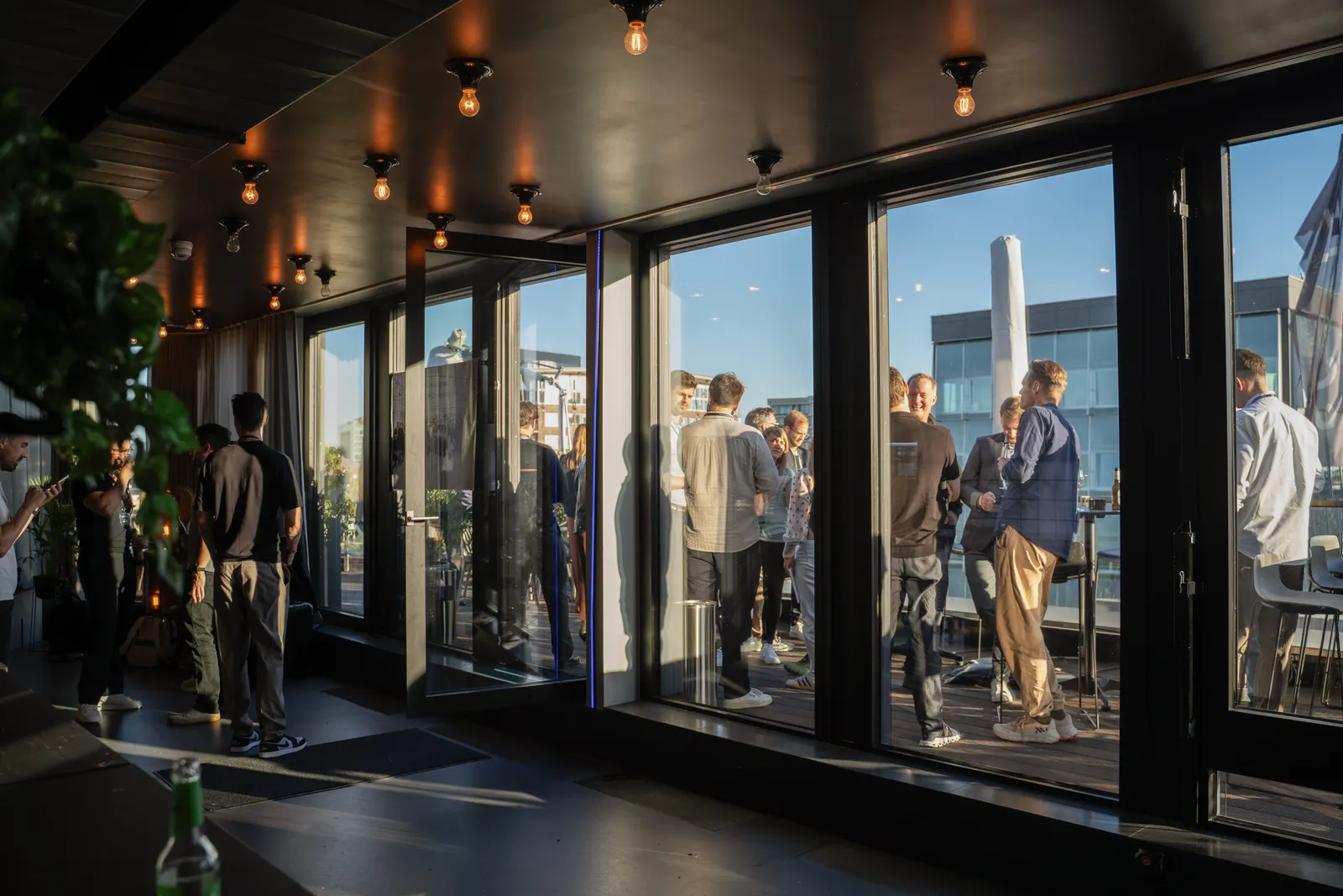 Kleine Gruppen im Gespräch an der Fensterfront.
