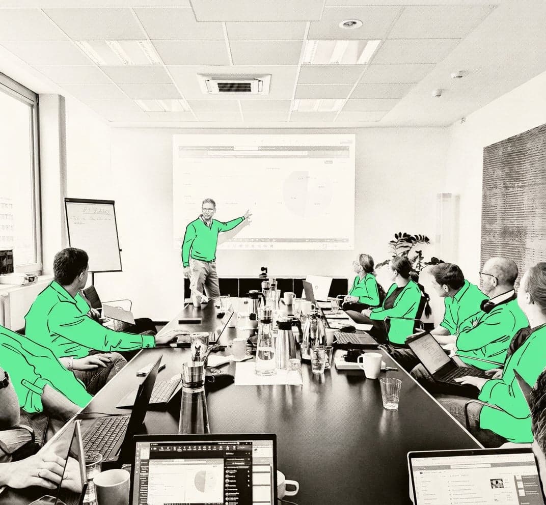Workshop bei Fröbel: Felix Schlenther erklärt am Bildschirm, das Team sitzt am Tisch