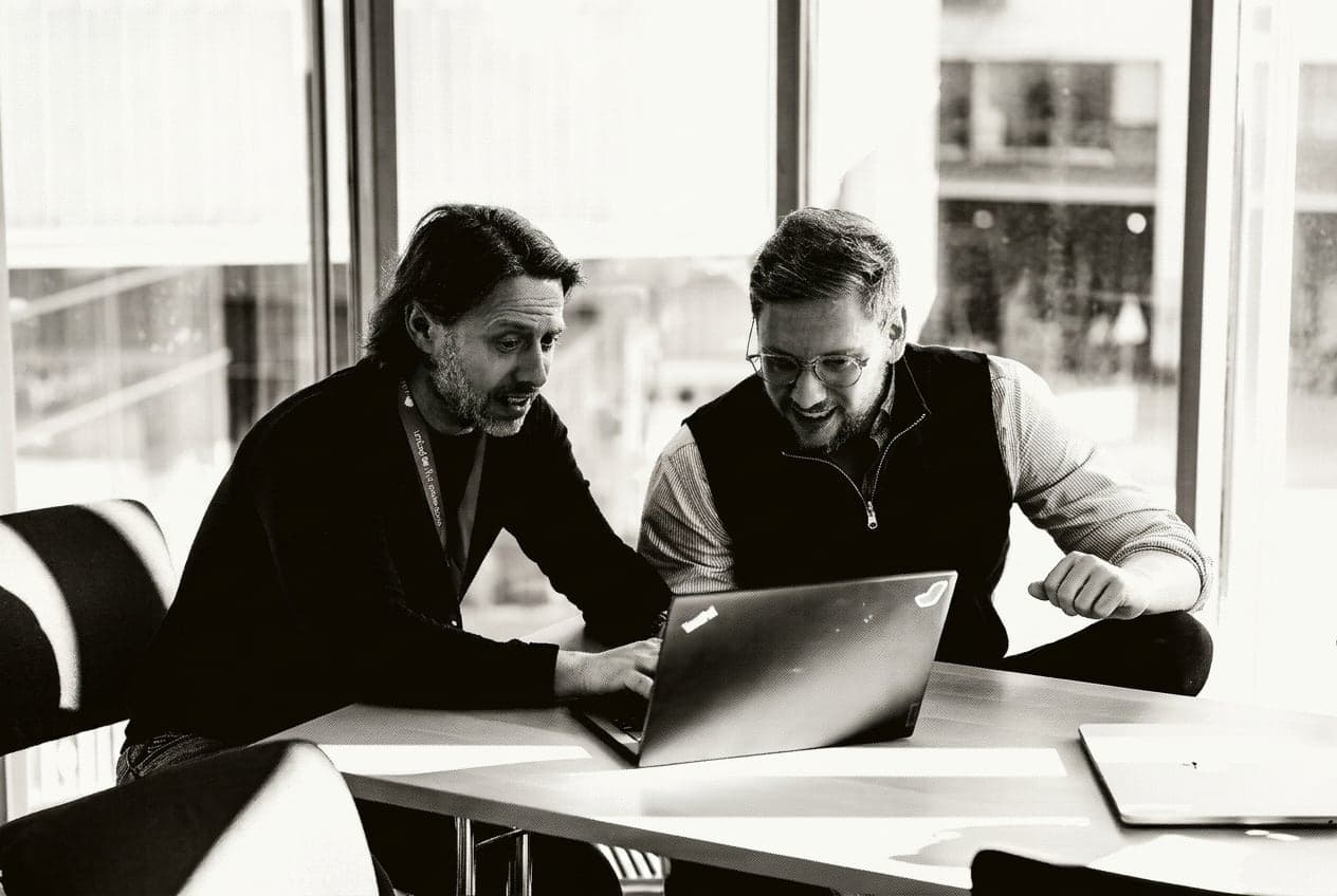 Zwei Teilnehmende arbeiten gemeinsam an einem Laptop